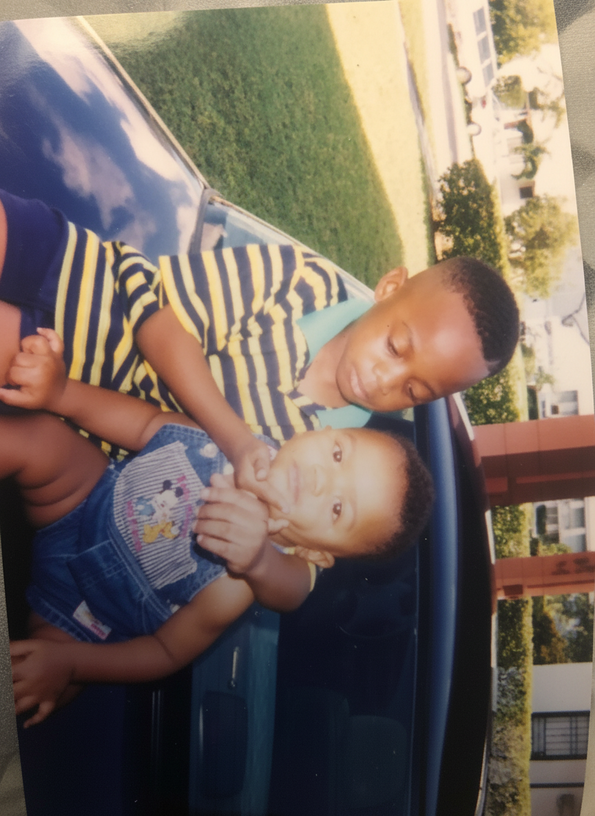 Anthony Robbins' two young sons sitting together on a car trunk