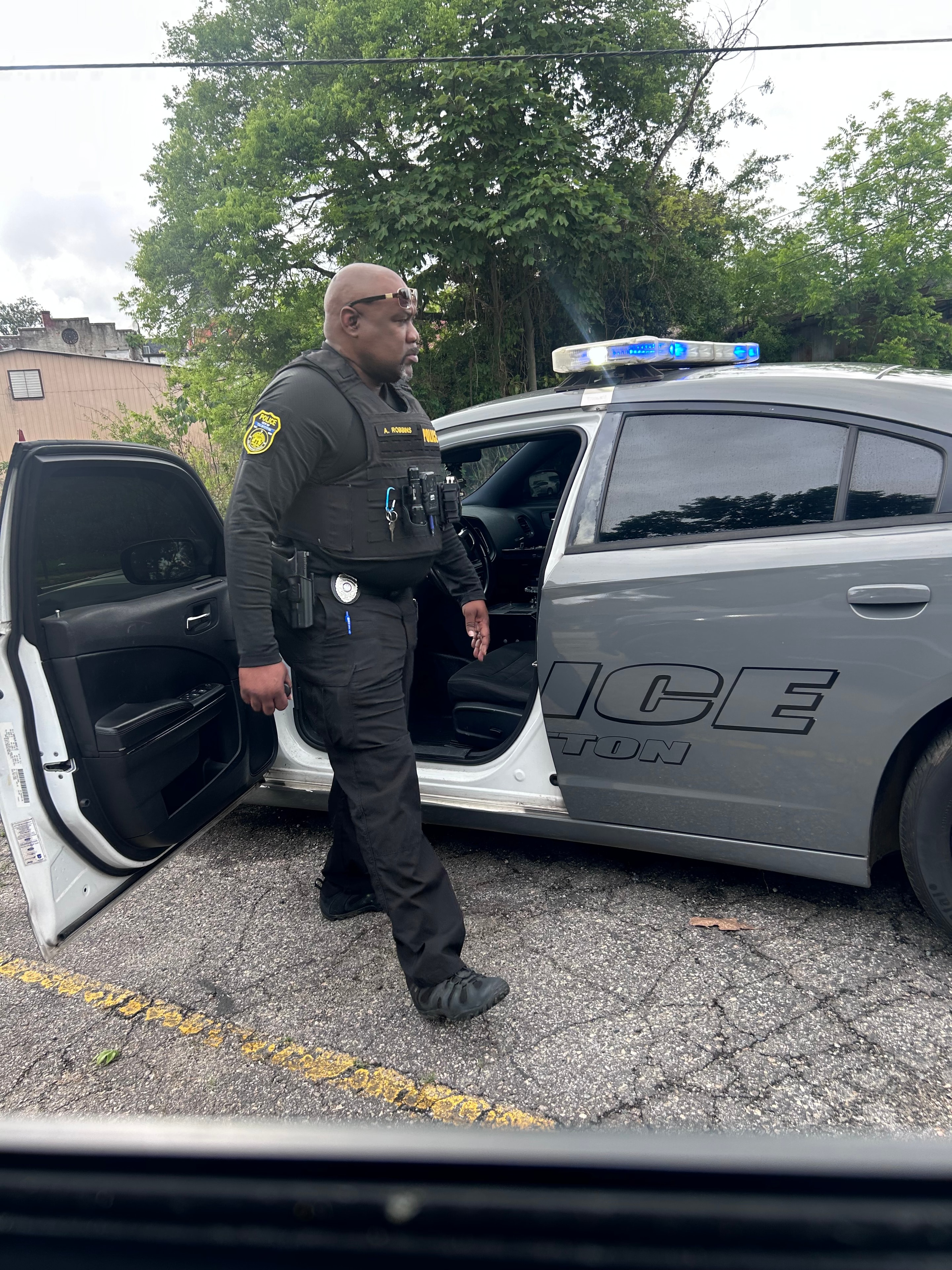 Anthony L. Robbins in uniform on active duty beside a police cruiser